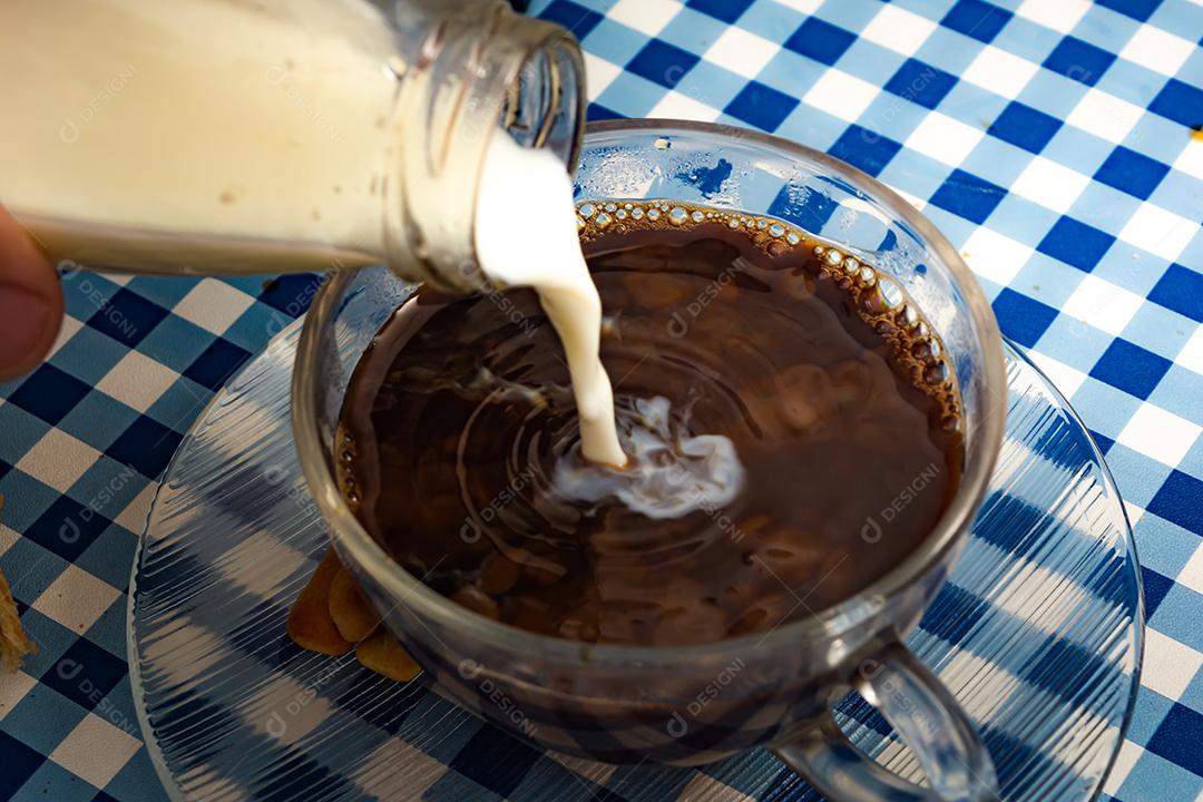 Café com Leite em xícara sobre fundo xadrez azul