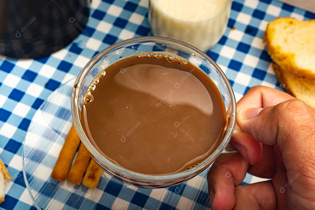 Pão com manteiga, leite, café em xícara, café da manhã, lanche sobre pano xadrez azul  mesa madeira