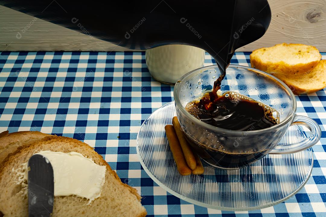 Pão com manteiga, leite, café em xícara, café da manhã, lanche sobre pano xadrez azul  mesa madeira