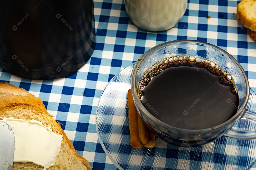 Pão com manteiga, leite, café em xícara, café da manhã, lanche sobre pano xadrez azul  mesa madeira