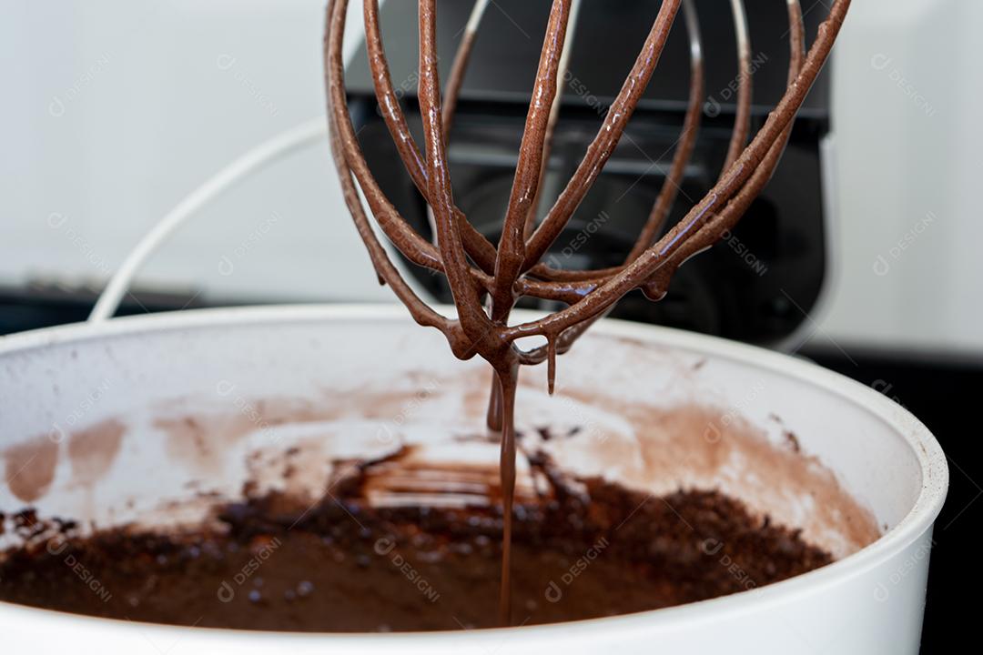 Massa de bolo de chocolate na batedeira sobre fundo branco