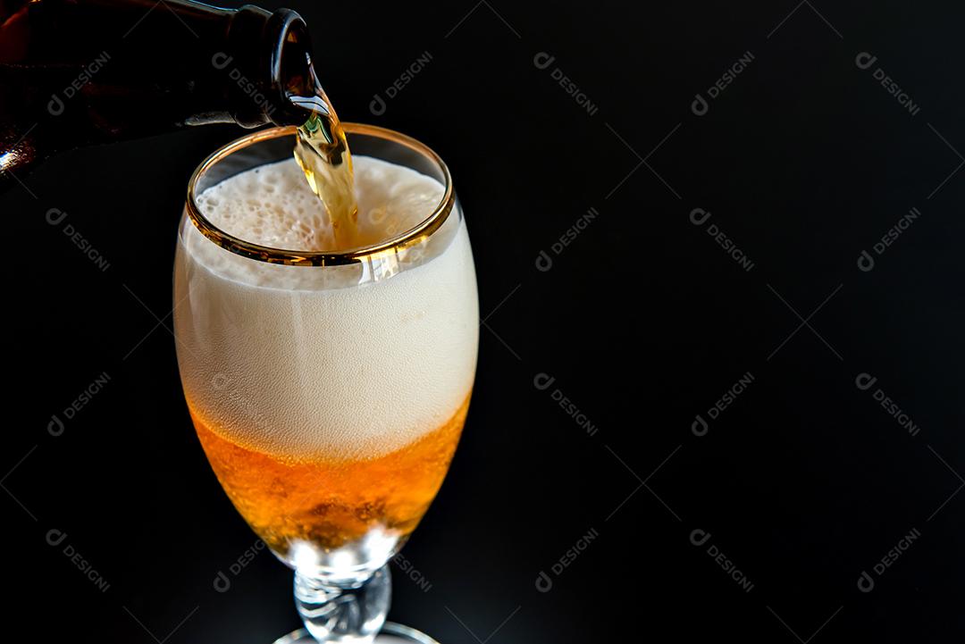 enchendo o copo de cerveja em fundo preto.