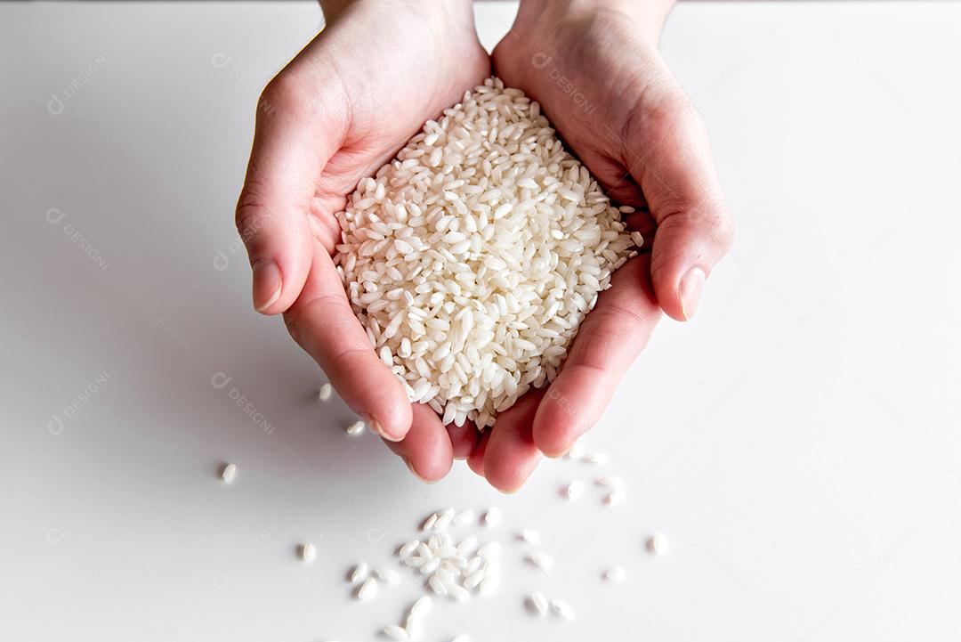 mãos segurando arroz arbóreo, arroz de risoto