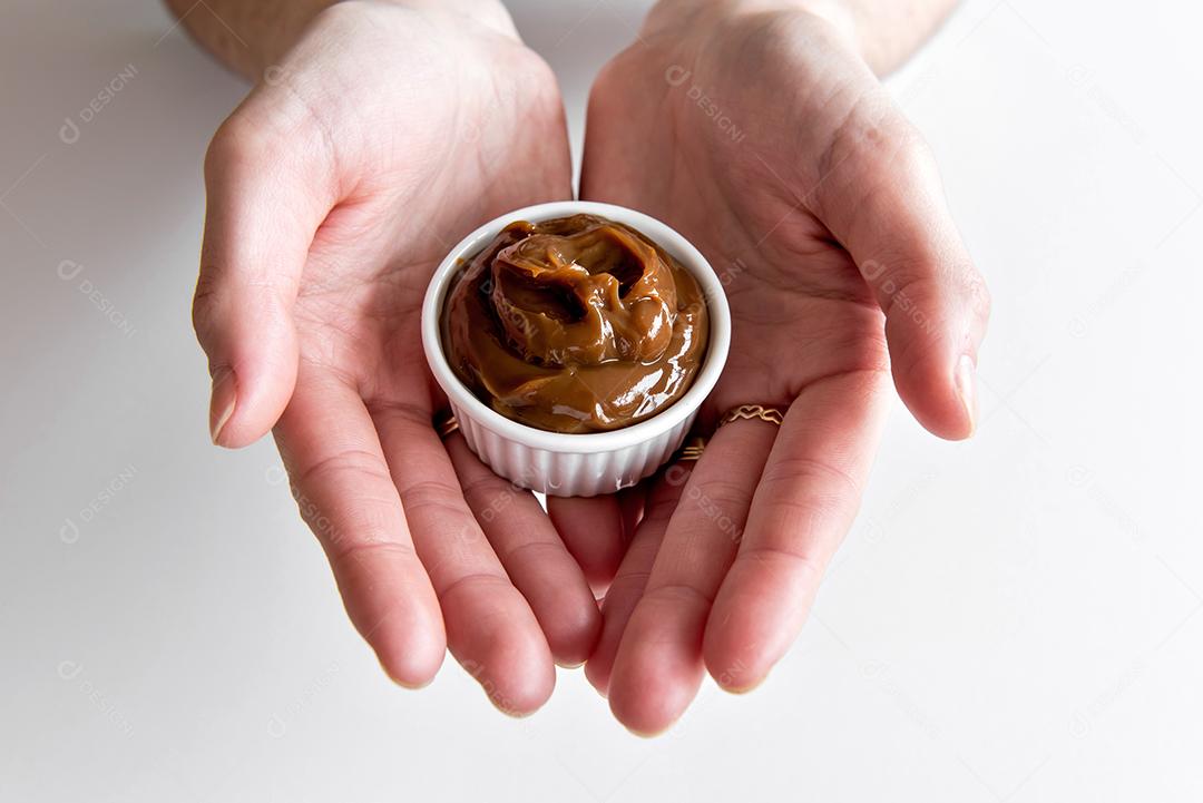 Mãos segurando doce de leite tradicional.