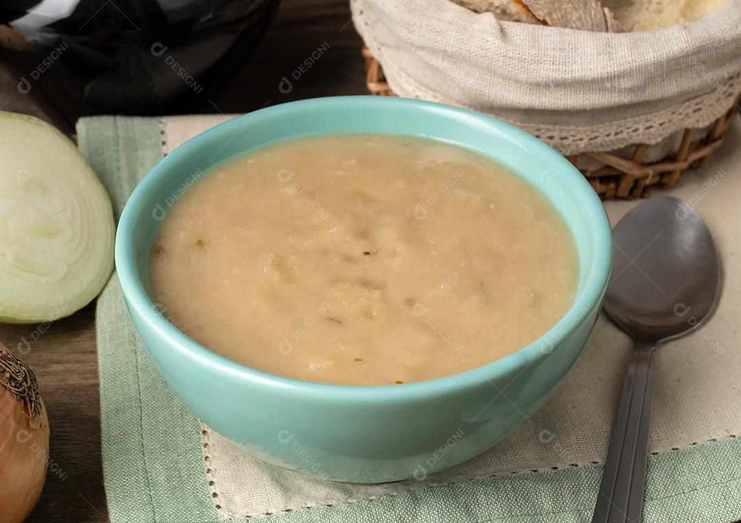 Sopa de cebola em uma tigela com pão e vinho.