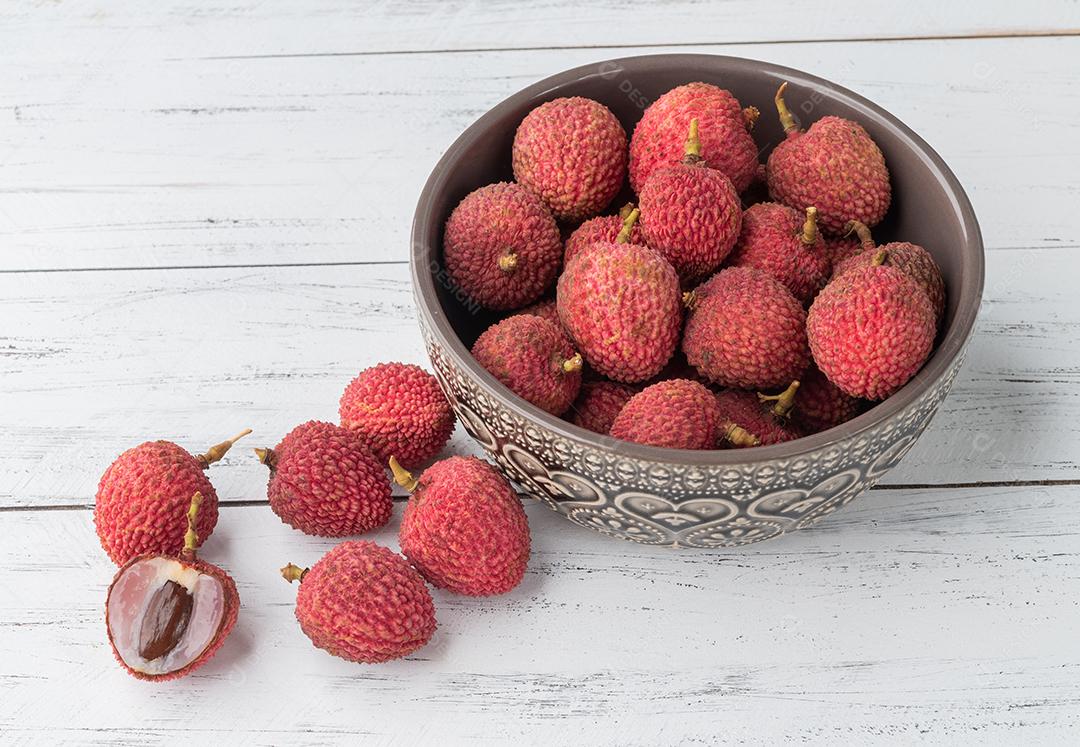 Lychees in a bowl on the wooden table.