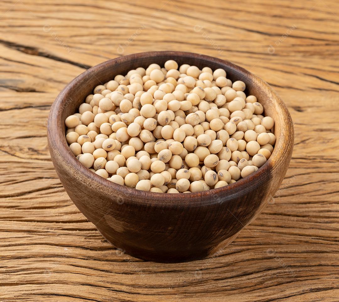 Soja crua em uma tigela sobre a mesa de madeira.