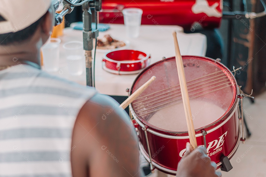 Pessoa tocando instrumento caixa bateria