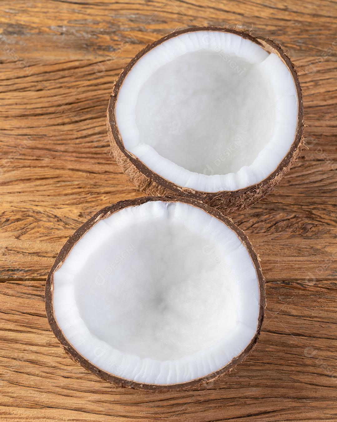 Coco rachado meia fruta sobre a mesa de madeira.