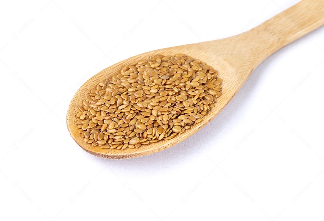 Linhaça dourada em uma colher isolada sobre fundo branco.