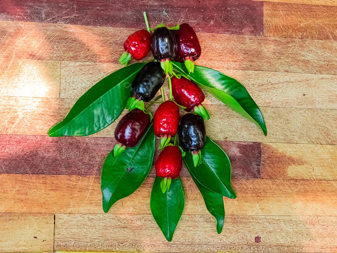 Fruta muda de cereja mesa madeira folha verde galhos