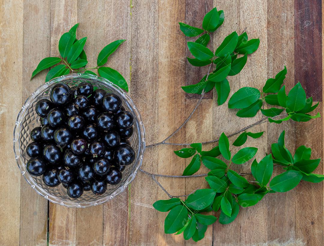 Jabuticaba sobre tigela mesa madeira folha verde