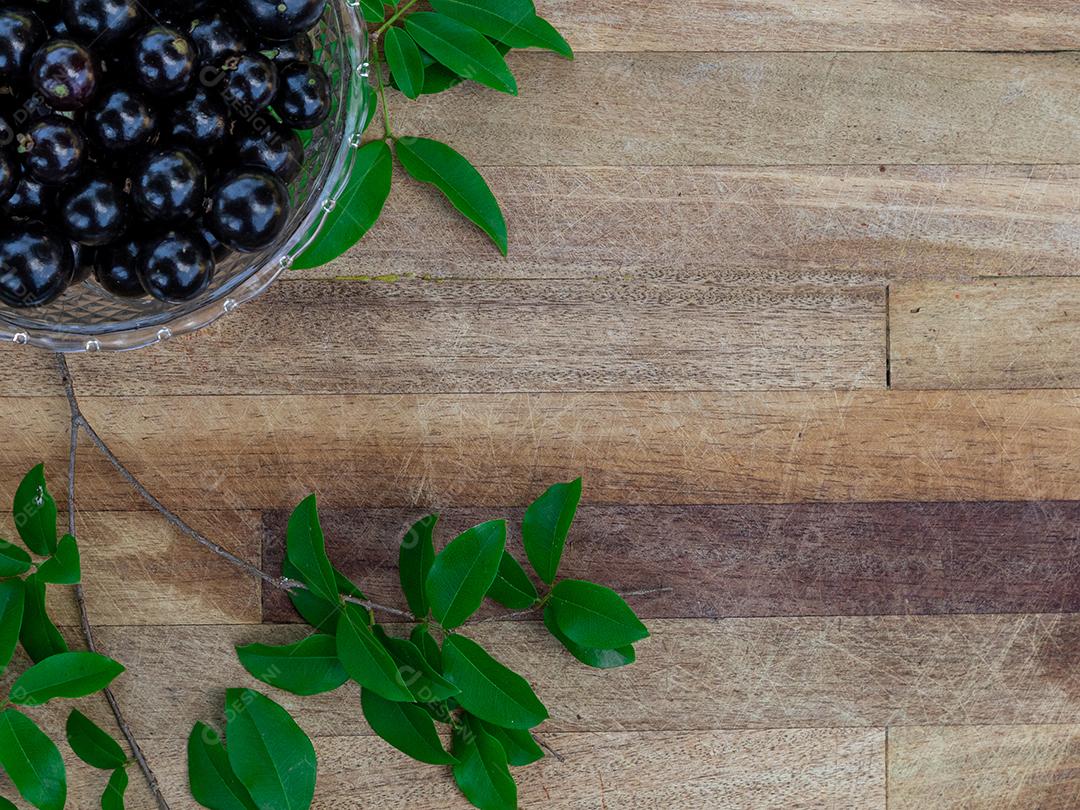 Jabuticaba sobre tigela mesa madeira folha verde