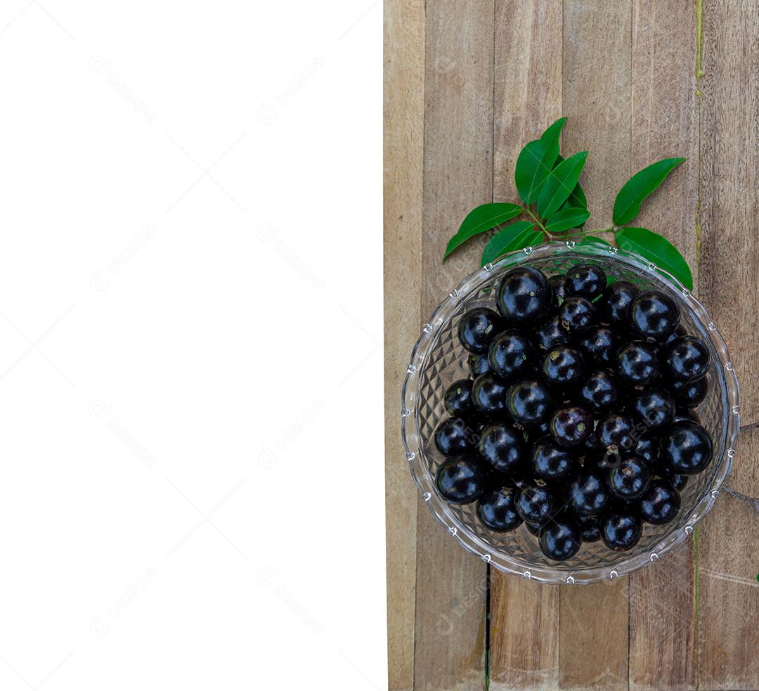 Jabuticaba sobre tigela mesa madeira folha verde