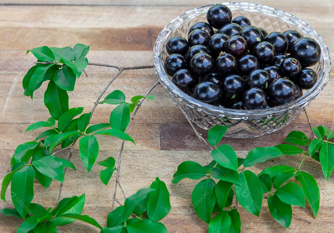 Jabuticaba sobre tigela mesa madeira folha verde