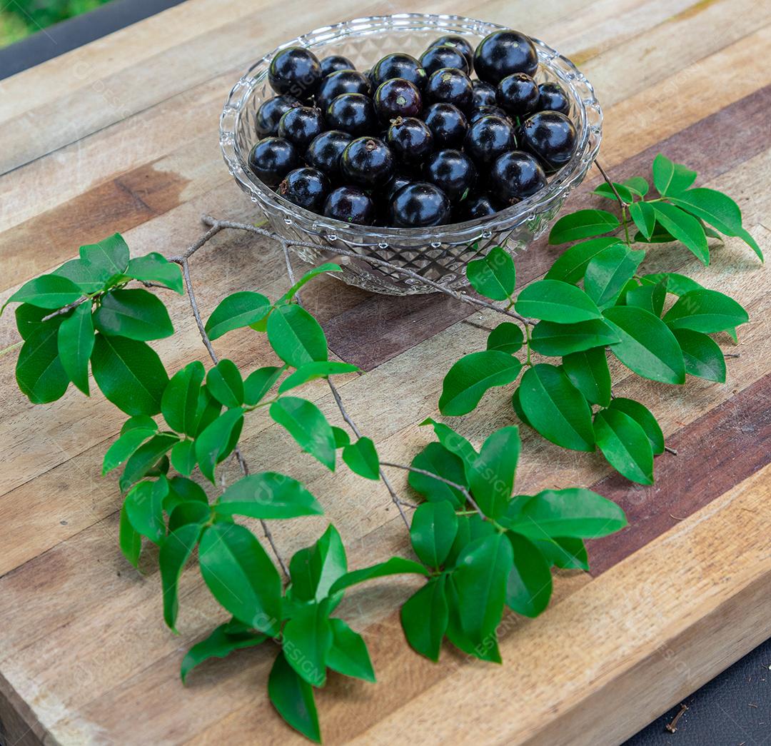 Jabuticaba sobre tigela mesa madeira folha verde
