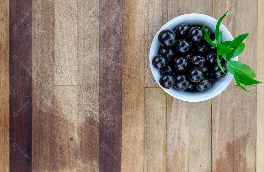 Jabuticaba sobre tigela mesa madeira folha verde