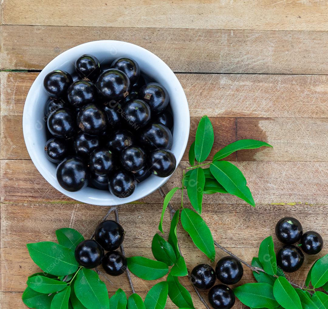 Jabuticaba sobre tigela mesa madeira folha verde
