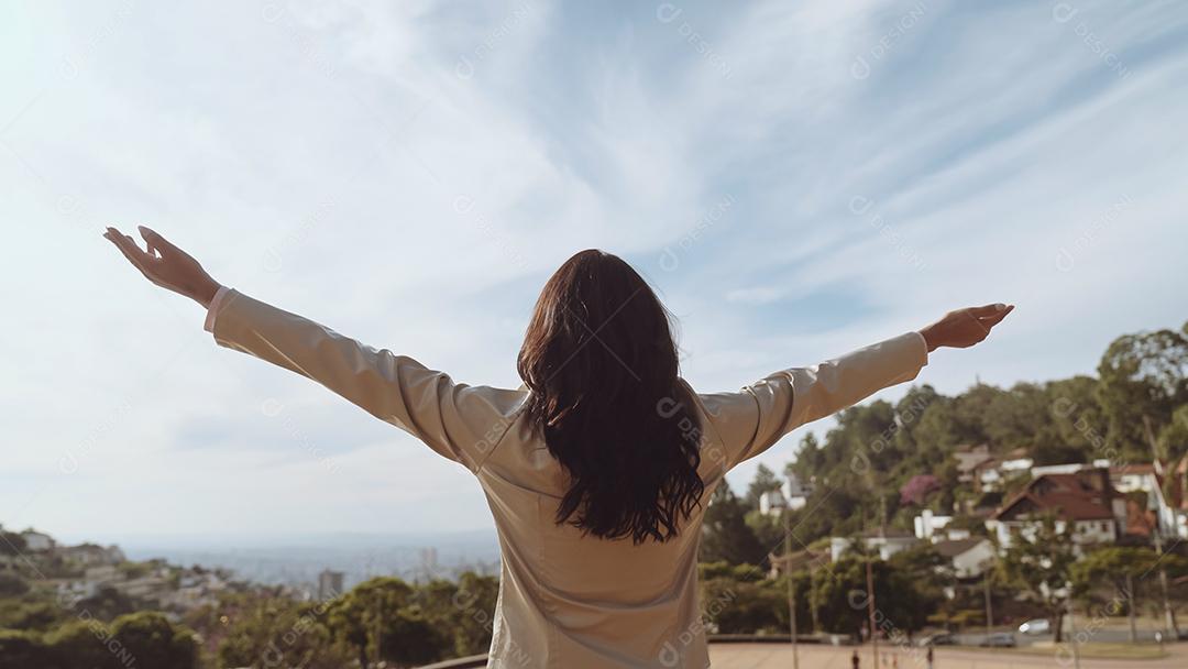 Mulher de costas na parte alta da cidade.