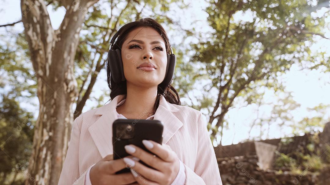 Linda jovem latina usando smartphone em pé na cidade st