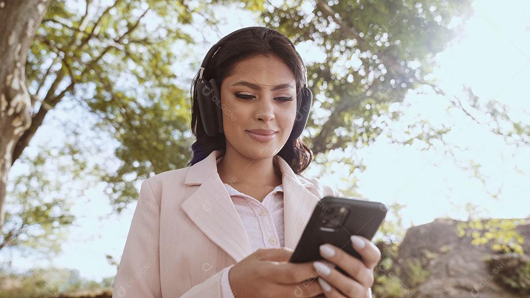 Linda jovem latina usando smartphone em pé na cidade st