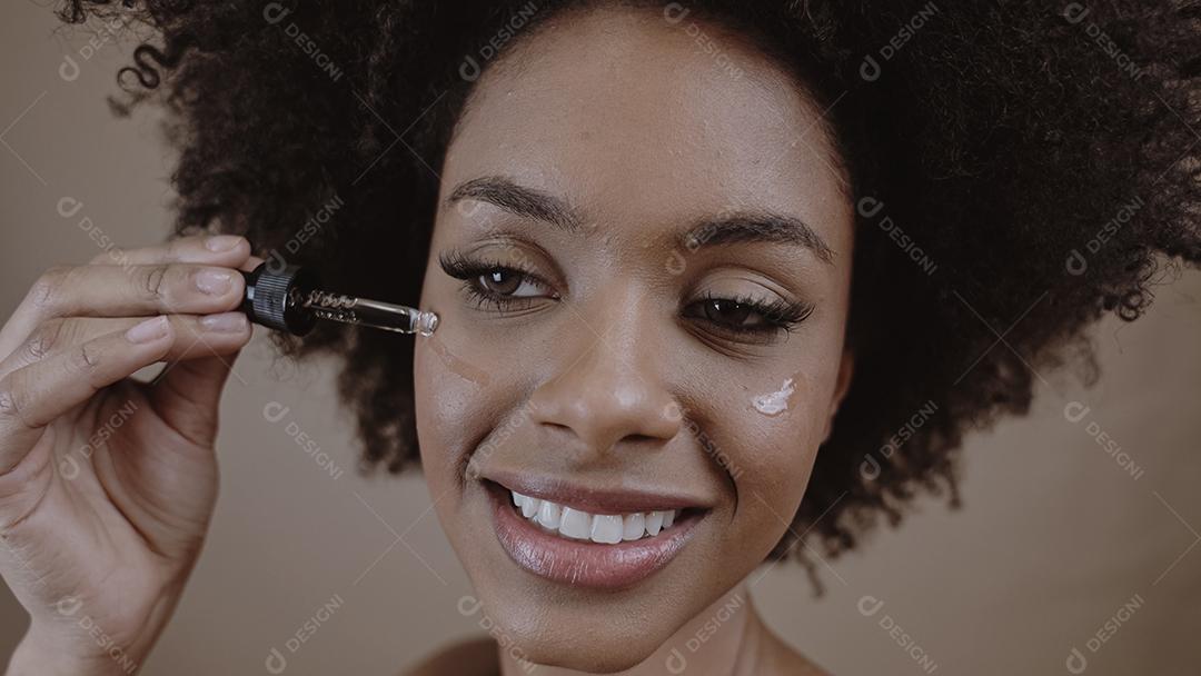 Feche o retrato de uma mulher latina aplicando soro hialurônico para h