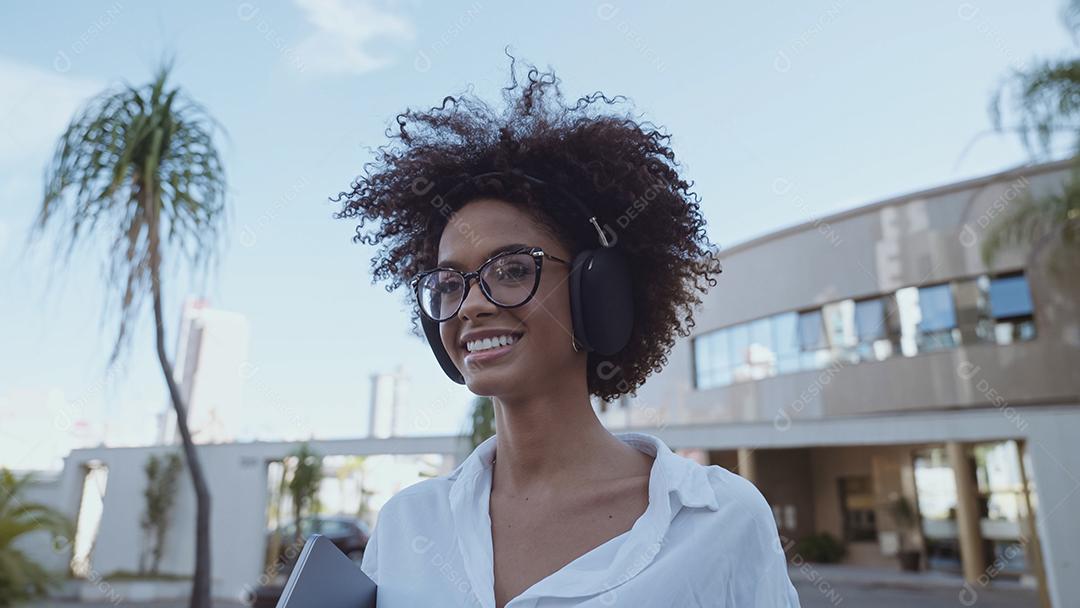 Visão de ângulo baixo da empresária latina sorridente segurando laptop e