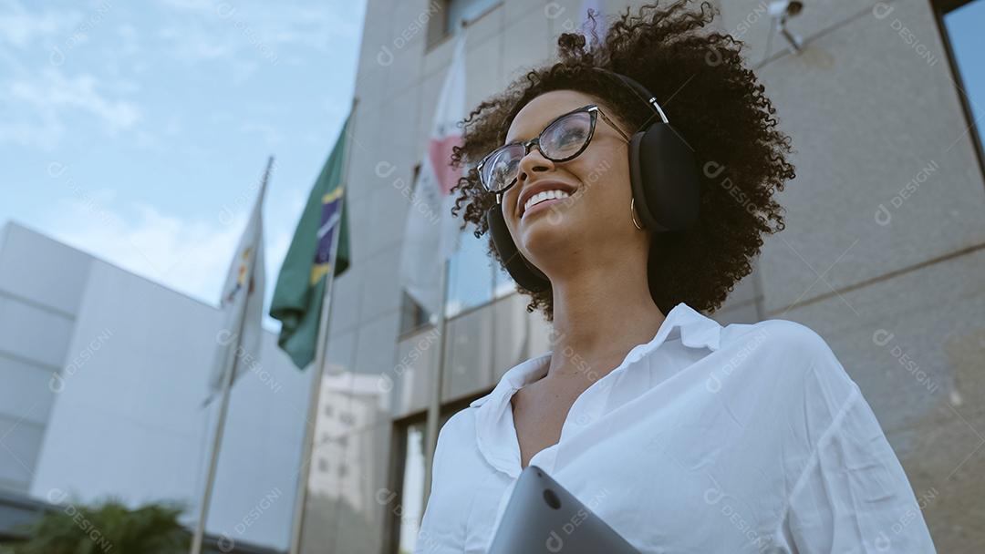 Visão de ângulo baixo da empresária latina sorridente segurando laptop e