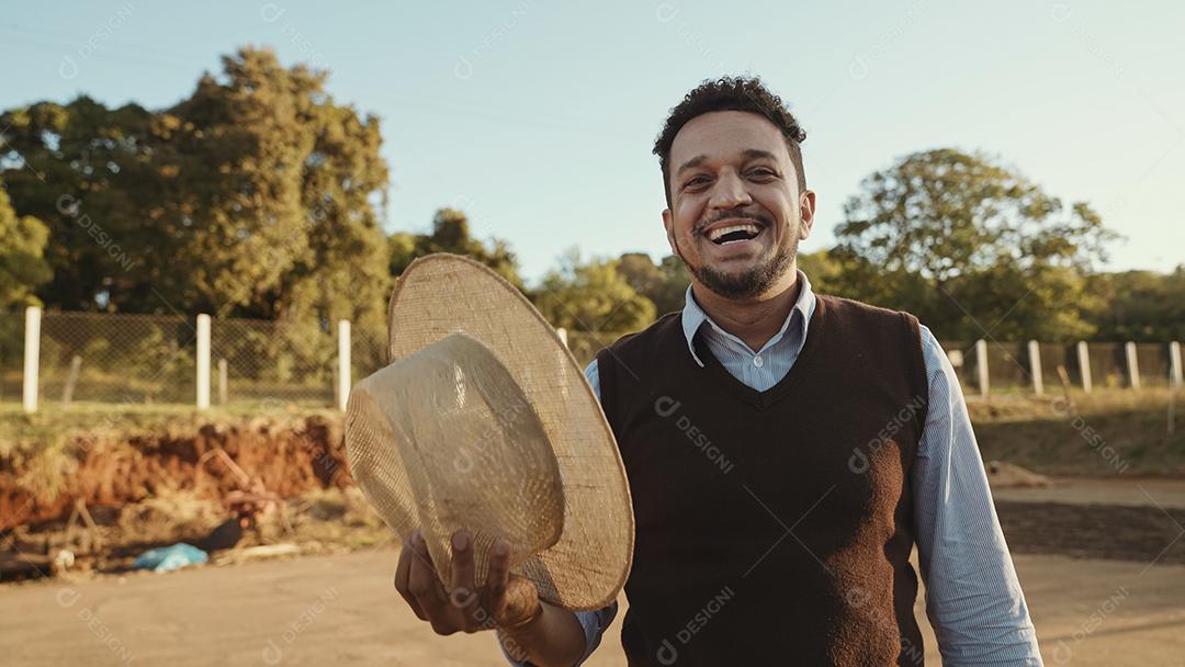 Portrait of young latin farmer in casual shirt taking off
