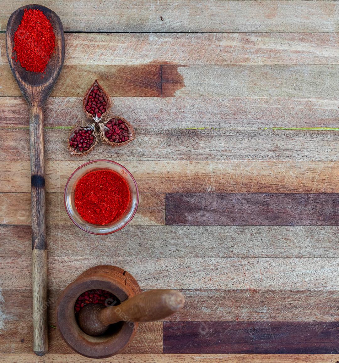 Urucum sobre uma mesa pilão colher de pau