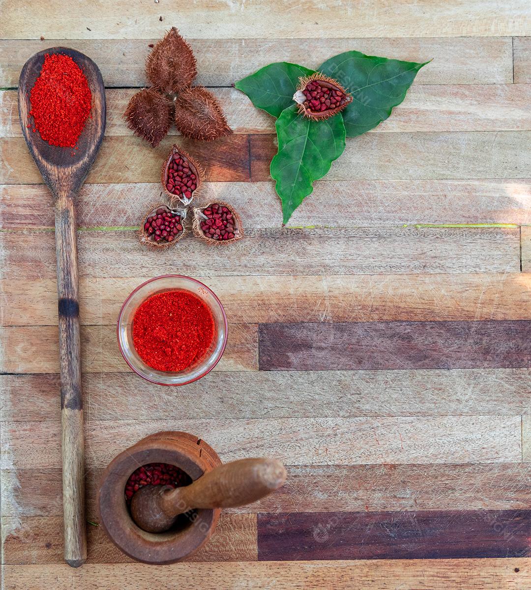 Urucum sobre uma mesa pilão colher de pau