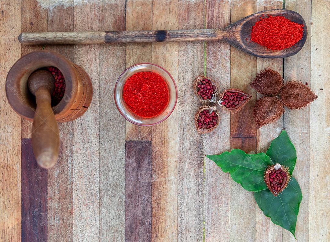 Urucum folha verde colher de pau mesa madeira
