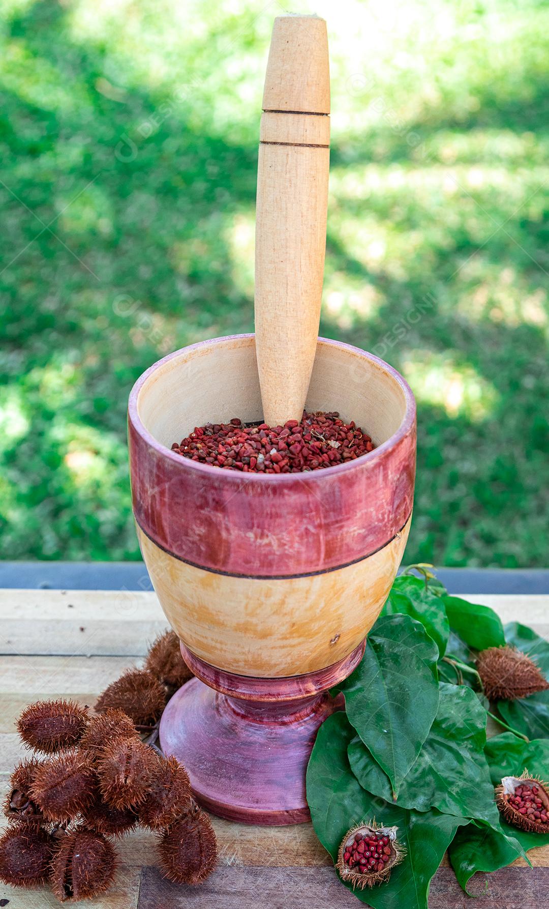 Urucum sobre uma mesa pilão colher de pau