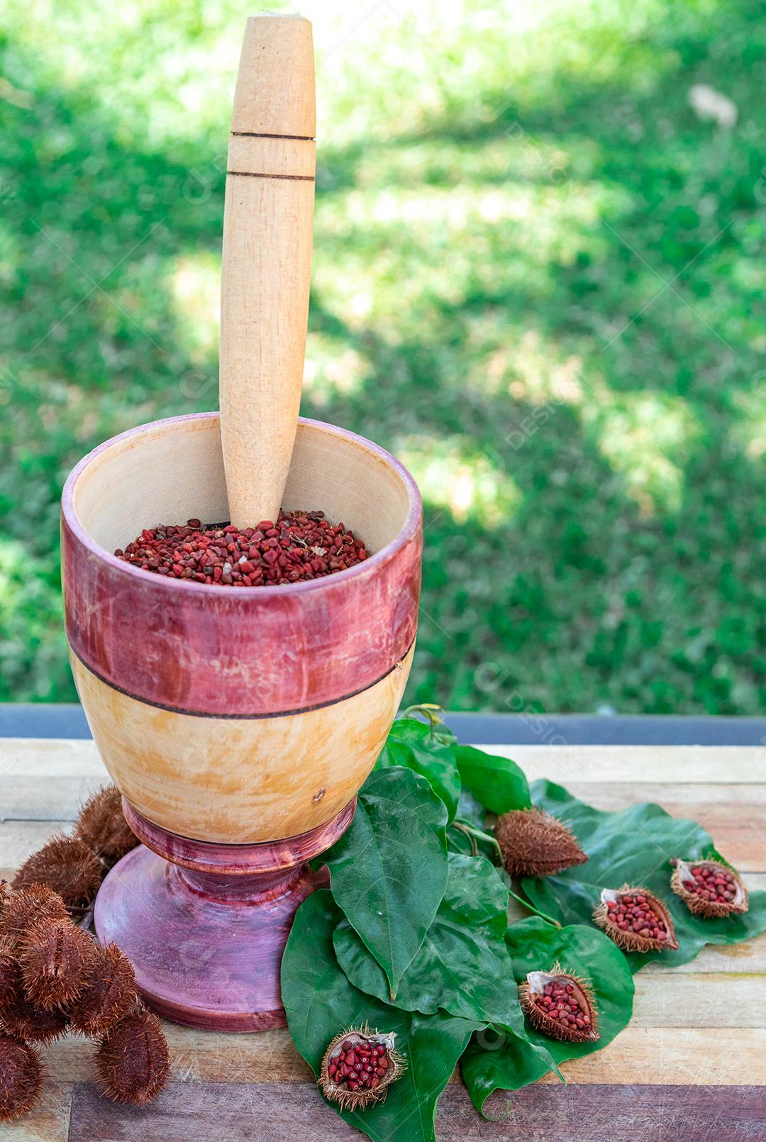 Urucum sobre uma mesa pilão colher de pau