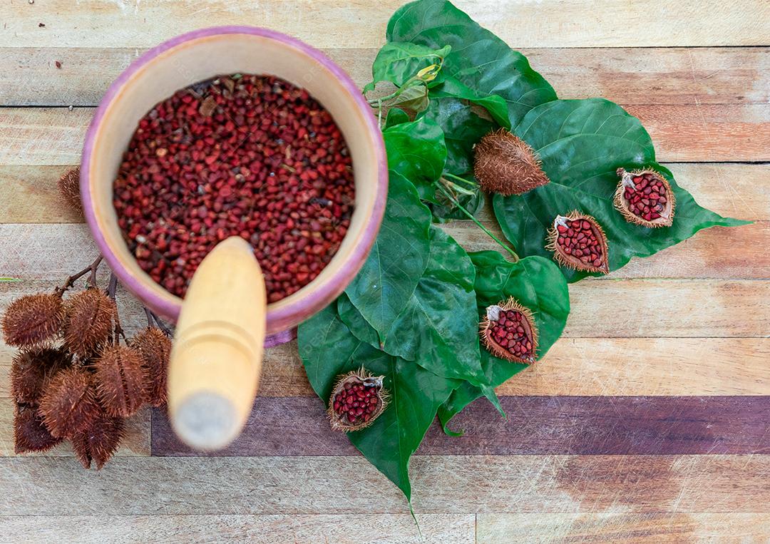 Urucum sobre uma mesa pilão colher de pau