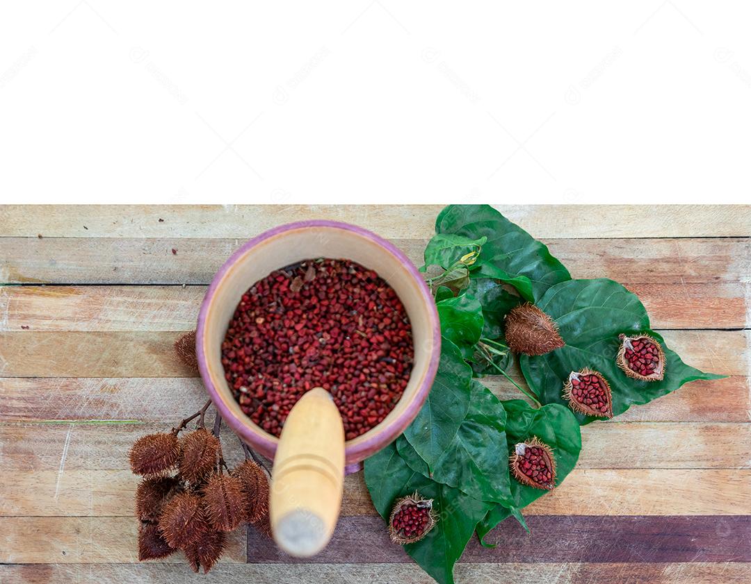 Urucum sobre uma mesa pilão colher de pau