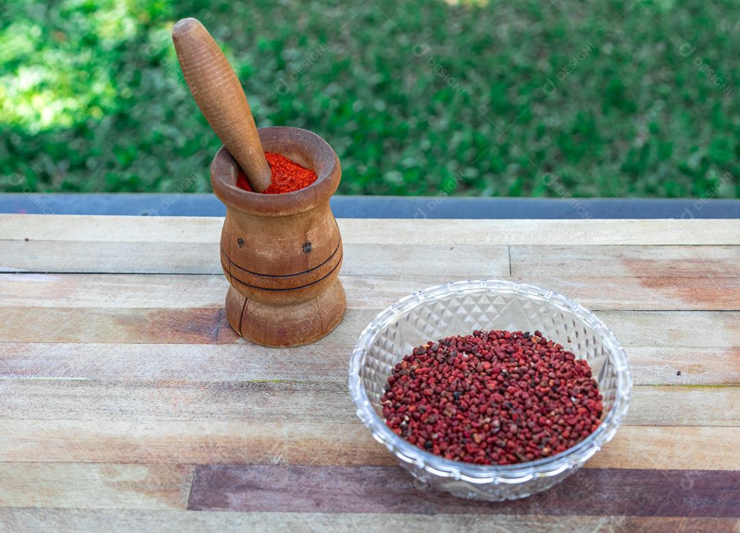 Urucum sobre uma mesa pilão colher de pau