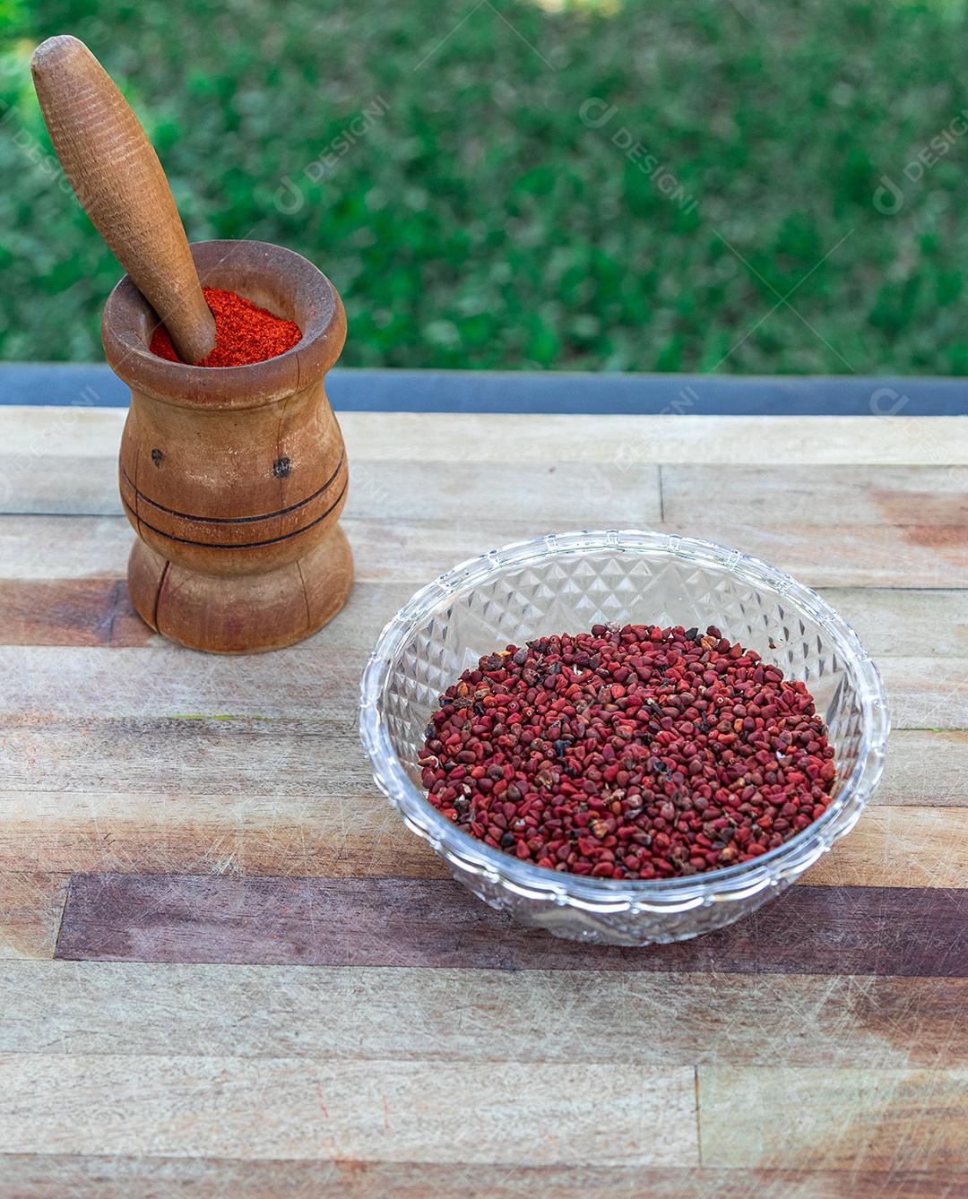 Urucum sobre uma mesa pilão colher de pau