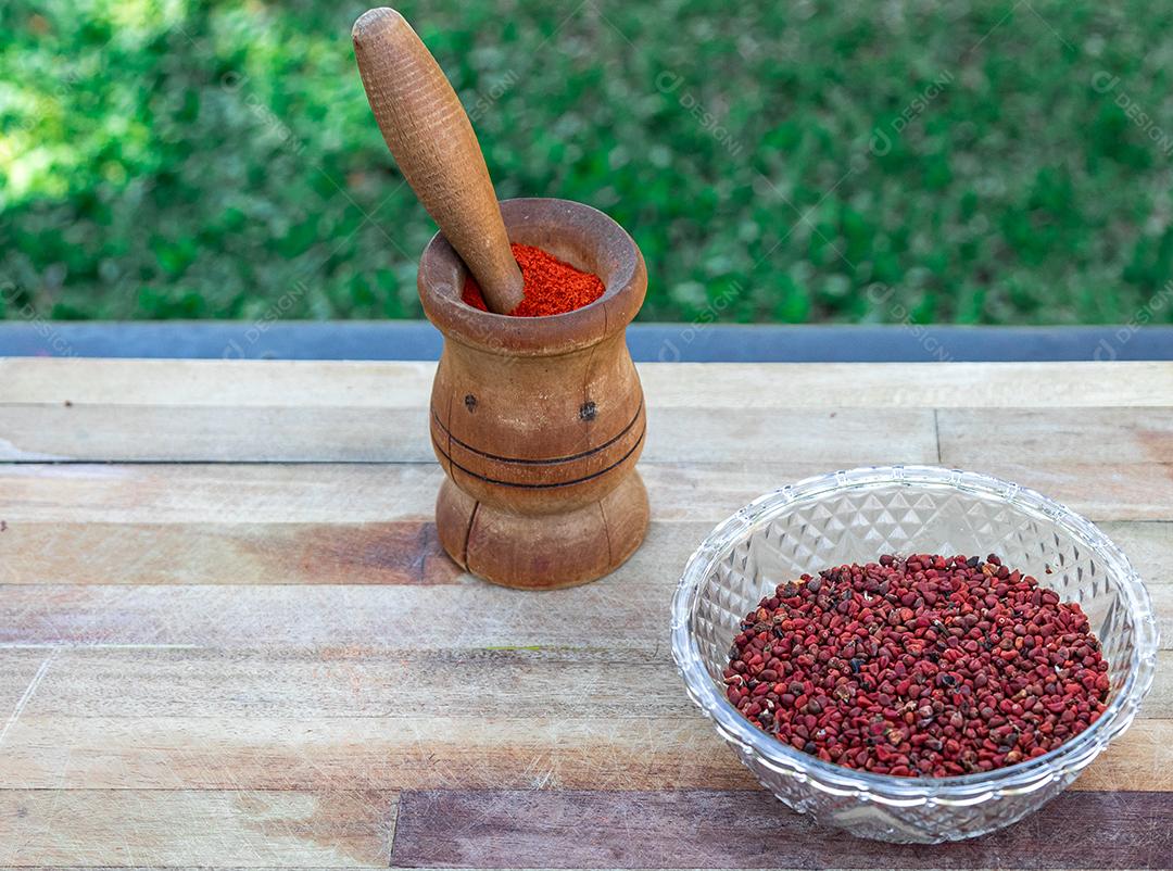 Urucum sobre uma mesa pilão colher de pau