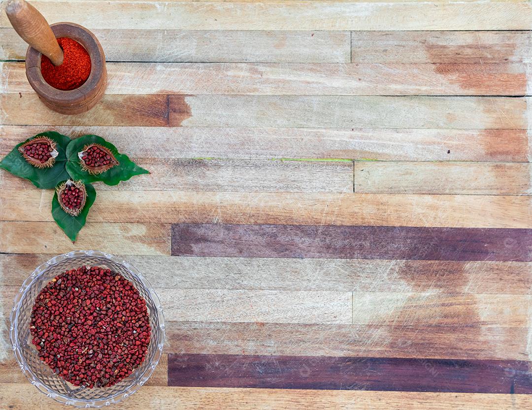 Urucum sobre uma mesa pilão colher de pau