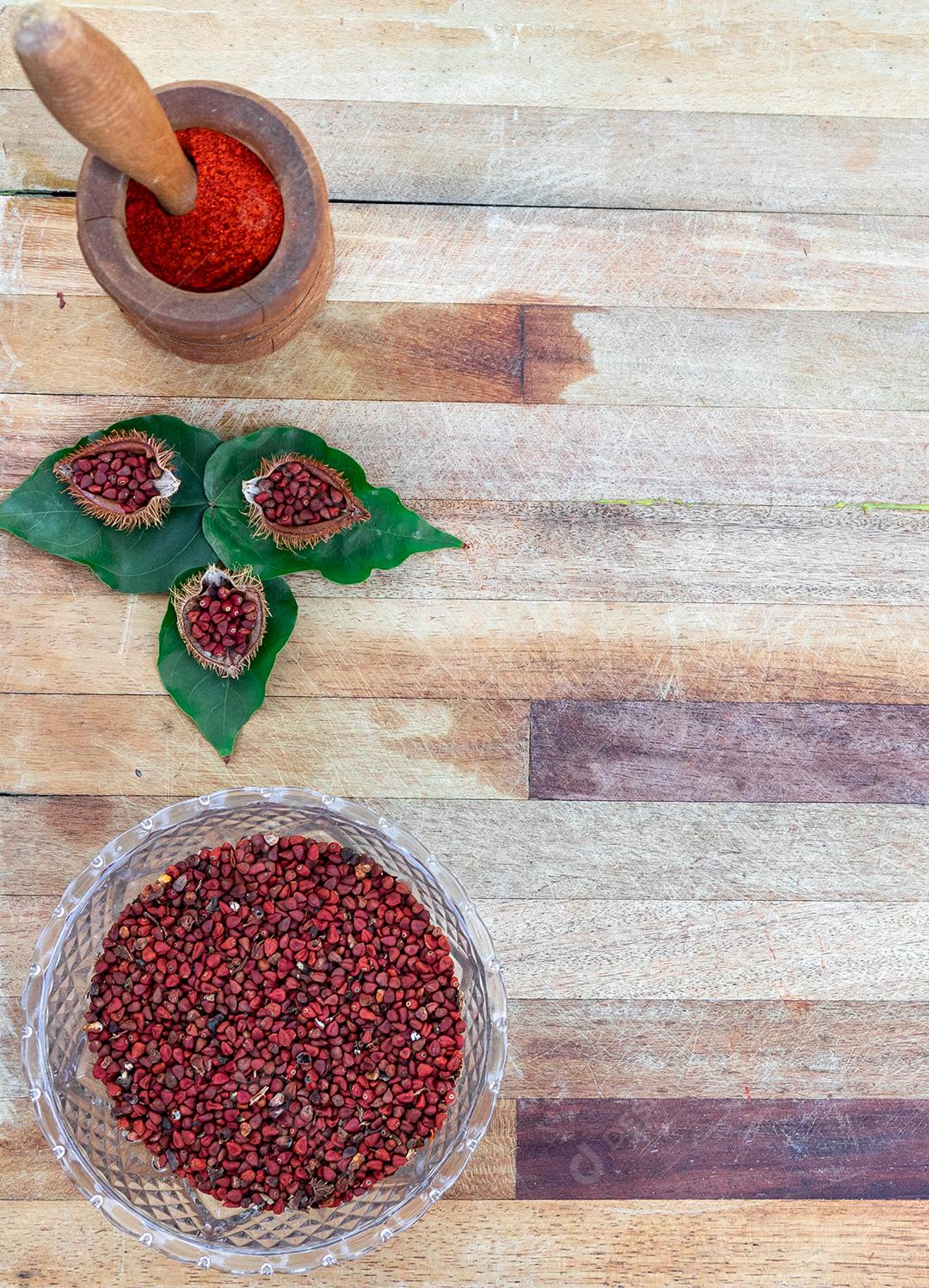 Urucum sobre uma mesa pilão colher de pau