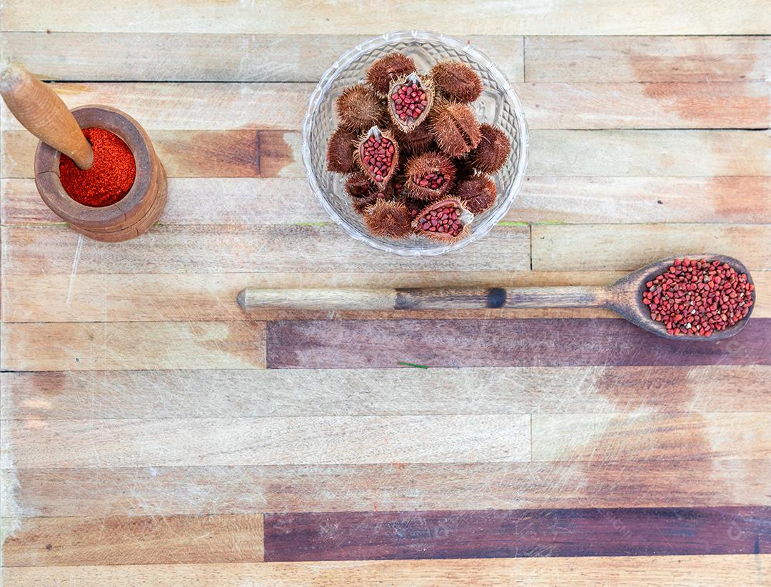 Urucum sobre uma mesa pilão colher de pau