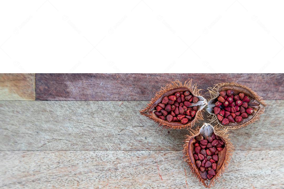 Urucum partido ao meio sobre uma mesa de madeira