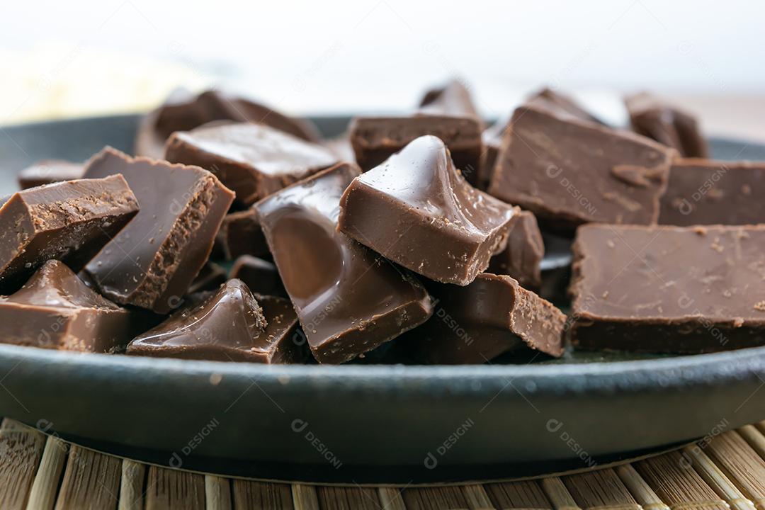 close-up tiro de pedaços de chocolate ao leite em um prato escuro