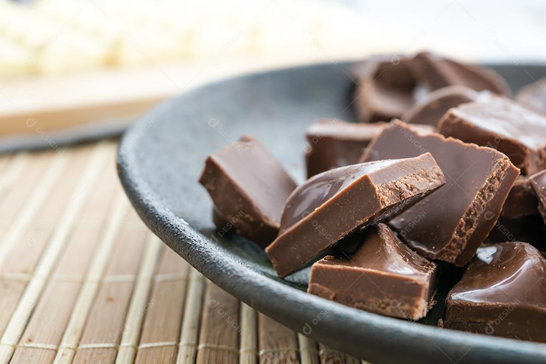 barra de chocolate branco e pedaços picados de chocolate ao leite, em um b