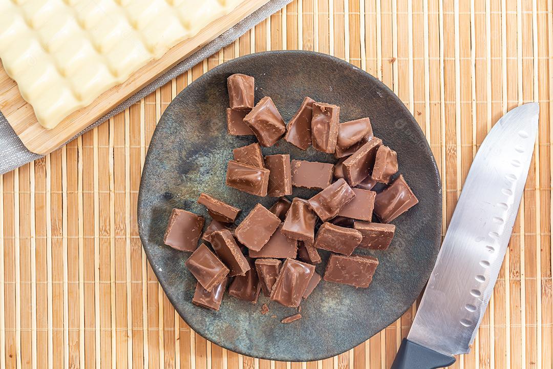 vista superior de pedaços de chocolate no prato escuro com chocolate branco