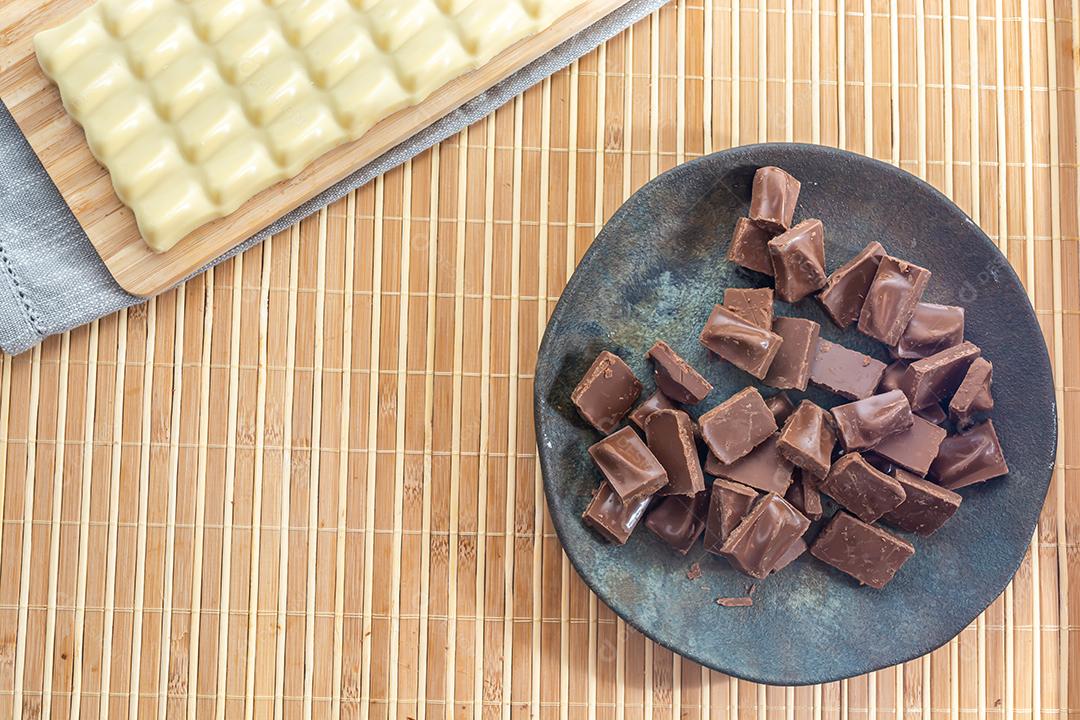 barra de chocolate branco e pedaços picados de chocolate ao leite, em um b
