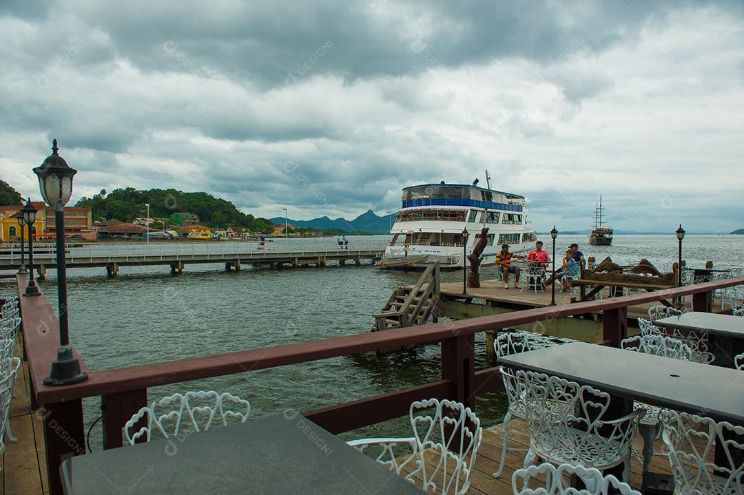 Porto com barcos e lugares para comer com céu azul