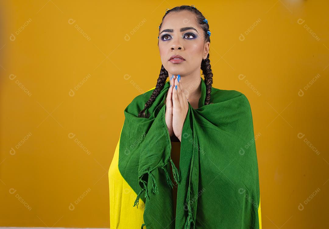 Fã brasileiro segurando a bandeira do Brasil em fundo cinza.