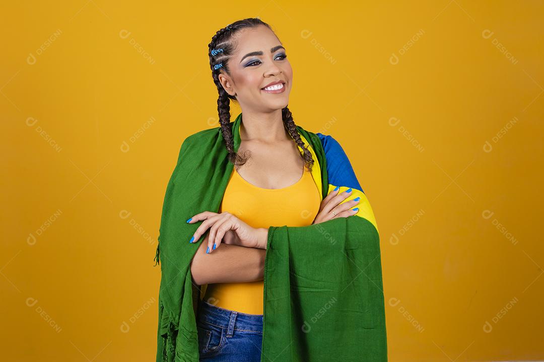 Torcedora brasileira. Fã brasileira comemorando partida de futebol em fundo cinza.
